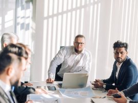 Optimistic businessman in white shirt collaborating with his team at meeting Optimistic businessman in white shirt collaborating with his team at meeting