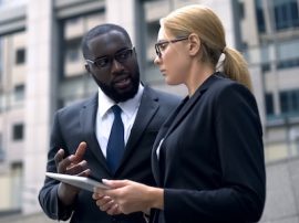 Client and executive discussing details of project on tablet, business plan Client and executive discussing details of project on tablet, business plan