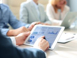 Business person analyzing financial statistics displayed on the tablet screen. Business person analyzing financial statistics displayed on the tablet screen.